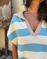 GILET OVERSIZE A RIGHE PANNA E CELESTE indossato, con scollo a V e righe azzurre e panna.