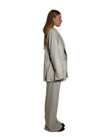 Side view of a woman wearing a blazer doppiopetto garcon flanella gessata in beige with tailored fit.