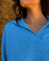 MAGLIONE CON SCOLLO A POLO CELESTE indossato in primo piano, evidenziando il morbido tessuto e l'iconico scollo a polo.