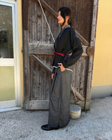 Model wearing KIMONO CORTO PATCHWORK NEW JAPANDI standing against a rustic wooden door.