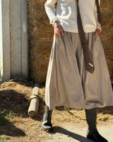 GONNA PANTALONE IN FLANELLA SABBIA indossata con maglione e cravatta, ambientazione naturale con fieno.